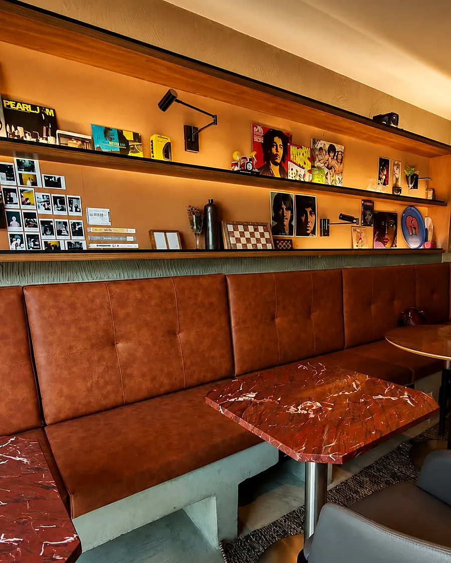 Estofado em couro e prateleiras iluminadas no Groove Café, reforma executada pela PJTT