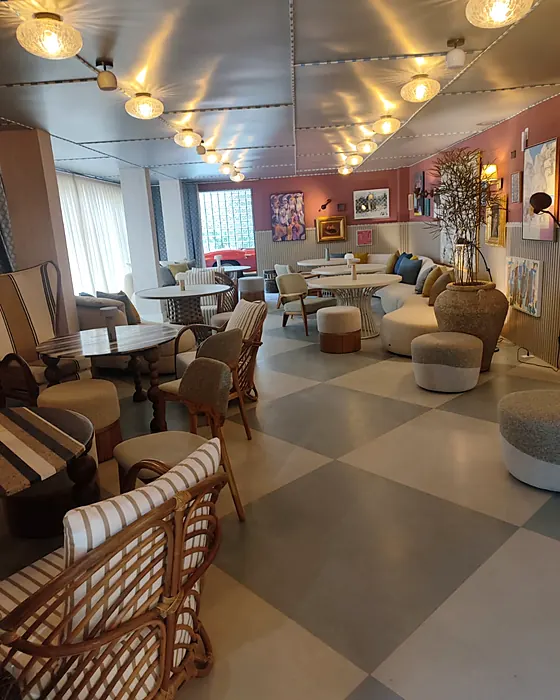 Salão com piso xadrez e poltronas, ambiente da Casa Cor 2026